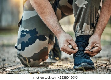 Man, hands and tying shoes in army getting ready for war, battle or fight on ground in nature. Closeup of male person tie shoe lace in preparation for training, exercise or gear in self defense - Powered by Shutterstock