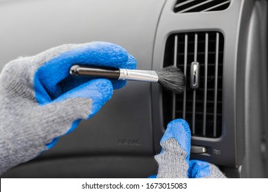 Man Hands Using Cleaning Brush And Removing Dust From Car Air Conditioning Vent Grille. Car Detailing Or Valeting Concept.