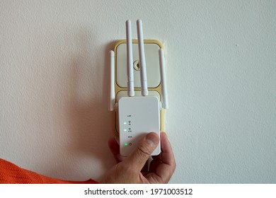 Man Hands Using A Wifi Repeater To Extend Network Coverage