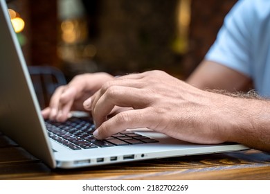 Man Hands Working On The Laptop In Cafe Or Coworking. Typing On Keyboard. Close-up. Soft Focus.