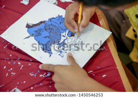 Man hands working are using craft knife, Process of hand cutting vinyl decals naga the snake in thai myth, Create vinyl decals