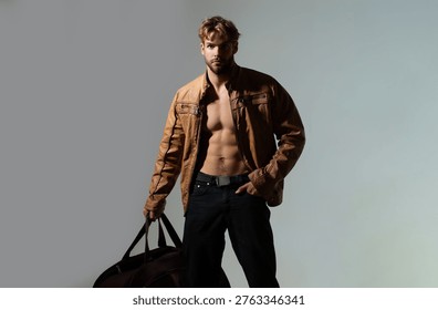 Man handsome model pose expression. Man bag travel journey lifestyle. Man dramatic light shadow contrast. Man strong masculine style.