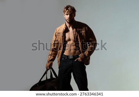 Man handsome model pose expression. Man bag travel journey lifestyle. Man dramatic light shadow contrast. Man strong masculine style.