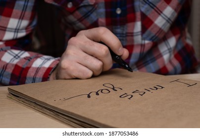 Man handwriting words I Miss You in a notebook. Man missing somebody and writing diary. - Shutterstock ID 1877053486