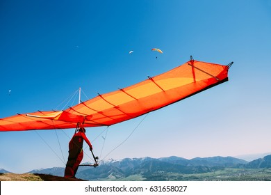 Man with hang-glider start to fly on the top of hill