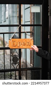 A Man Hangs A Sign On The Cafe Door Open