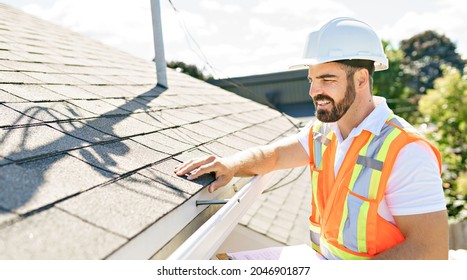 A man in a hard hat, holding a clipboard, standing on the steps of an old rundown house. - Shutterstock ID 2046901877