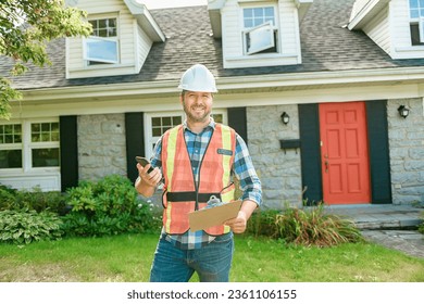 A man with hard hat standing in front of a house to inspect - Powered by Shutterstock