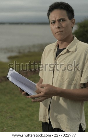 A man has an expression of concern on his face as he look up from a book that he is reading.