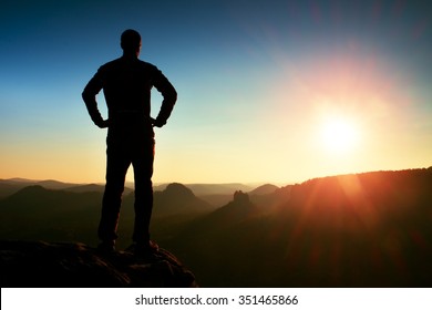 A Man Has His Hands On  Hips. Sportsman  Silhouette In Nature Within  Daybreak.