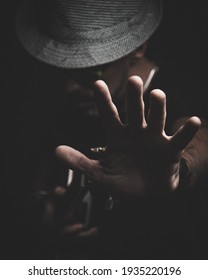 A man With a hat in the dark