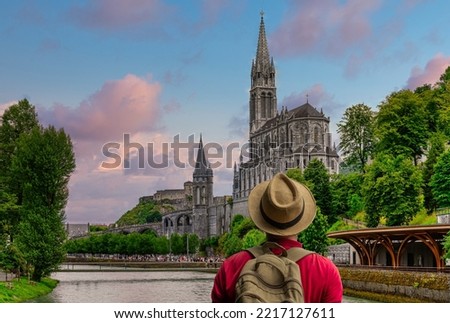 Man with hat looking at the Sanctuary of Our Lady of Lourdes 
