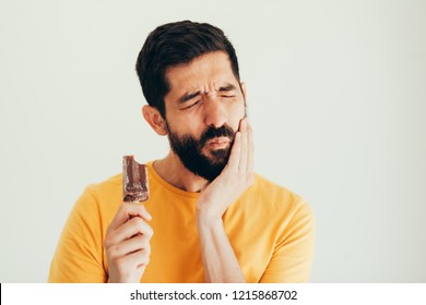Man have sensitive teeth with ice on white background