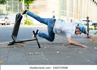 Man Having Accident Falling From E-Scooter On Street