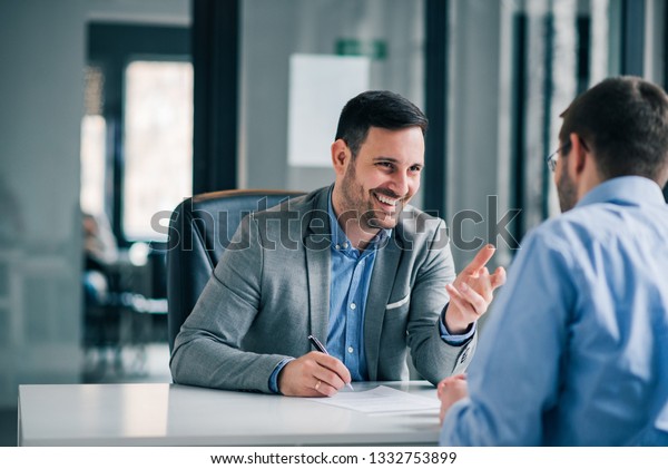 Man having a business meeting and signing a\
contract, recruitment or\
agreement.