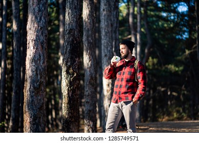 Man having a cup of coffee in the woods - Powered by Shutterstock