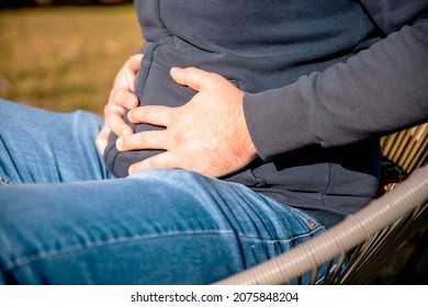 Man Having Gastric Pain, Due To Constipation, Holding Hands On Stomach. Closeup