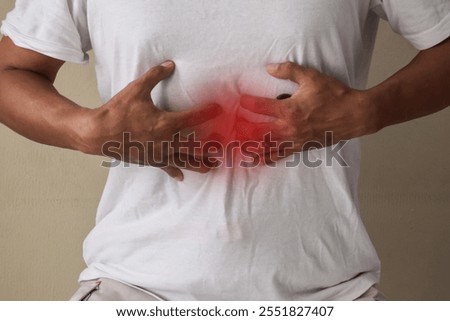 Man having gastric problems on gray background