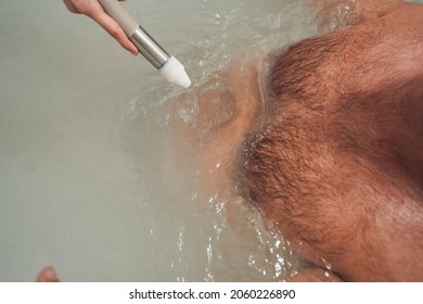 Man having hydromassage procedure in spa center