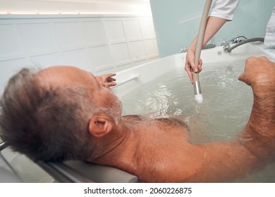 Man having hydromassage procedure at wellness spa center