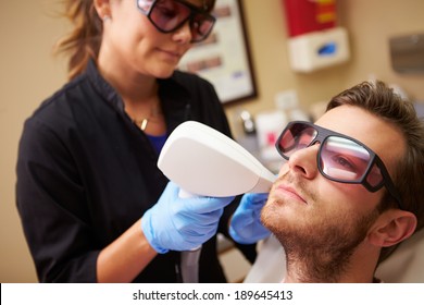 Man Having Laser Treatment At Beauty Clinic