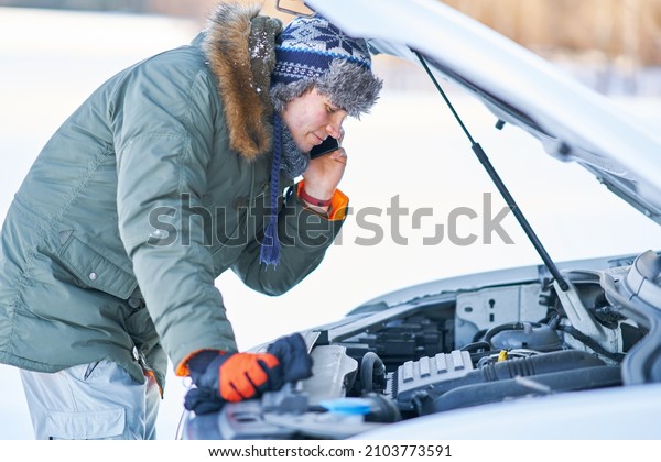 Man having\
problem with car during snowy\
winter