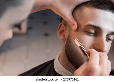 Man having a shave at the barber shop. - Powered by Shutterstock