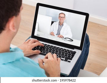 Man having video chat with doctor on laptop at home - Shutterstock ID 195978422