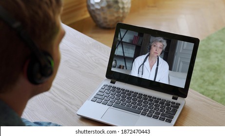 Man Having Video Conferencing With Online Woman Doctor. Remote Patient Consulting Video Call In Conference Virtual Webcam Chat App. Over Shoulder Laptop Screen View.