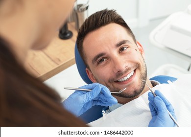 Man Having A Visit At The Dentist's. Handsome Patient Sitting On Chair At Dentist Office In Dental Clinic.