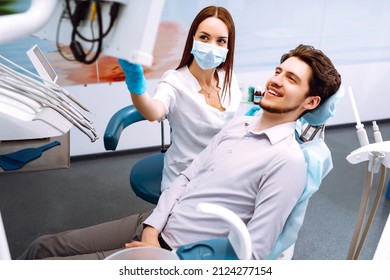 Man Having A Visit At The Dentist's. Handsome Patient Sitting On Chair At Dentist Office In Dental Clinic. Healthy Teeth And Medicine Concept.
