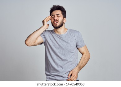     man with a headache on a gray background                            - Shutterstock ID 1470549353