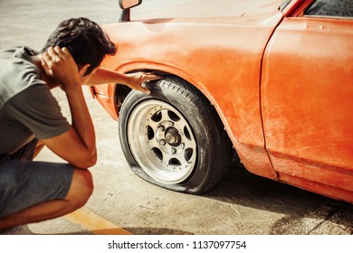 A man headache when car breakdown and wheel flat tire in parking