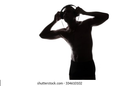 man with headphones listening to music - beautiful male body - athletic torso 