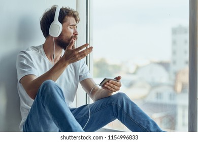 man with headphones looking out the window                             