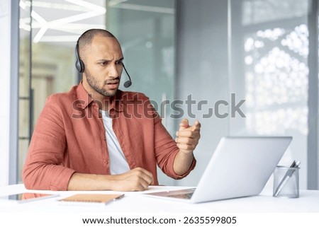 A man with a headset gestures emphatically during a video call, expressing surprise and consternation with his facial expression.