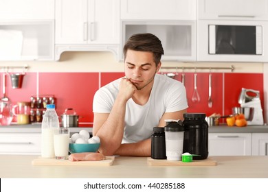 Man with healthy food and sports nutrition in kitchen
