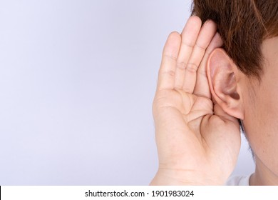 Man Hearing Loss Or Hard Of Hearing And Cupping His Hand Behind His Ear Isolate Grey Background, Deaf Concept.