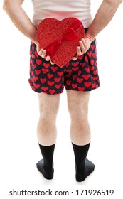 Man In Heart Underwear Holding A Box Of Valentine's Day Candy Behind His Back.  Isolated On White.  