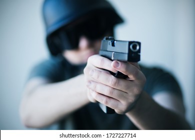 A Man In A Helmet And Protective Black Glasses Holds A Gun In His Hands And Takes Aim. Police. Army. Crime.