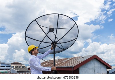 Man with helmet work with satellite communication dish.