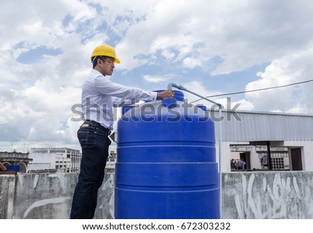 Man with helmet work  with water tank.