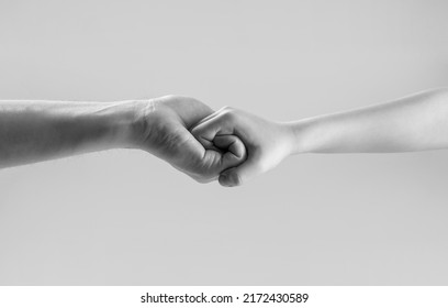 Man help hands, protection. Male and child hands connected each other together and forever. Black and white.