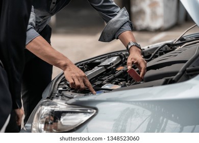 Man Help Woman Fix The Car Problem. He Pop Up The Car Hood To Repair The Damaged Part.