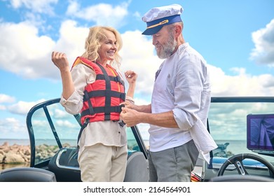 A Man In Helping A Blonde Woman To Put On The Life Vest