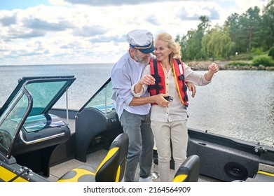 A Man In Helping A Blonde Woman To Put On The Life Vest