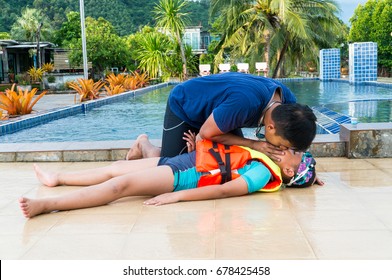 Man Helping Drowning Child In Swimming Pool By Doing CPR.