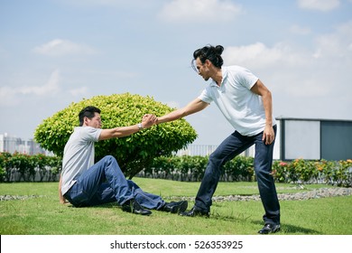 Man Helping His Friend To Stand Up