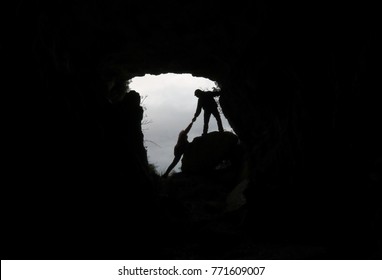 MAN HELPING A PERSON IN A CAVE - Powered by Shutterstock