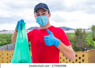 Man Helping Poor People Giving Them Food And Water In Quarantine Lockdown For The Covid-19 - Young Adult Working Alone Wearing Medical And Surgical Mask To Prevent Coronavirus